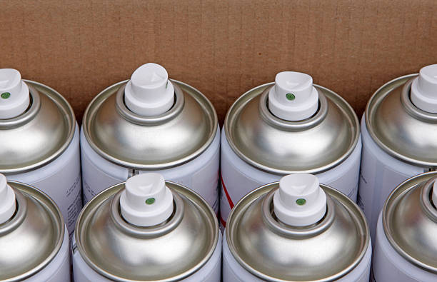 Flammable aerosols including spray paint, glue, and compressed gas cans prepared for UK hazardous waste recycling