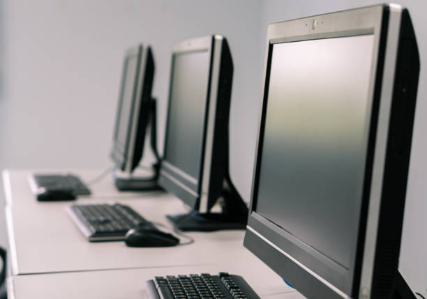 Desktop computer on office desk with nature reflection on window, promoting free PC and laptop recycling.
