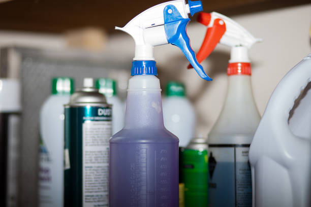 Assorted janitorial supplies including cleaning bottles, brushes, and gloves prepared for recycling or disposal.