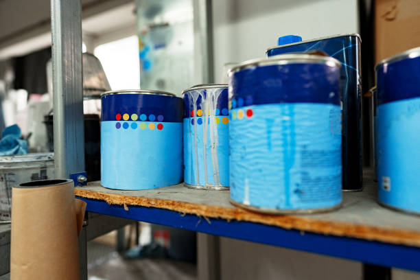 Various used paint tins containing leftover paint prepared for recycling or proper disposal.